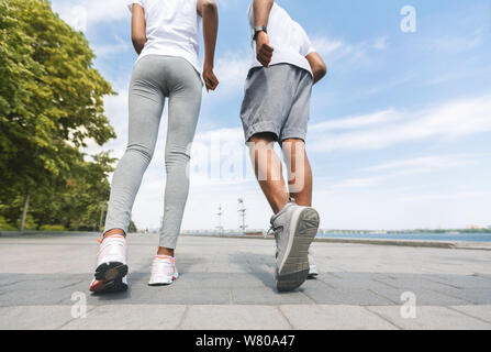 Nicht erkennbare Schwarz Paar Joggen entlang der Ufer, Low-Angle, Rückansicht Stockfoto