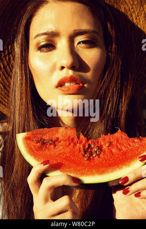 Portrait glückliche junge Frau hält ein Stück Wassermelone. Geschmack Wassermelone. Sommer. Früchte. Stockfoto