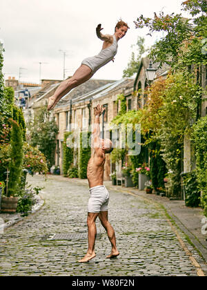 Edinburgh, Schottland, Vereinigtes Königreich, 7. August 2019. Edinburgh Festival Fringe 2019: Fotoshooting für Nikki Rummer und JD Broussé (Nikki und JD), eine akrobatische Zirkus Duo mit Fähigkeiten in der Zirkus- und zeitgenössischen Tanz, der in "Knoten", Teil des British Council Edinburgh Showcase 2019, mit Hand-auf-Hand circus Skills zu einer Reise durch die Kämpfe der Engagement vermitteln. In Circus Lane in Edinburghs Neustadt fotografiert. Stockfoto