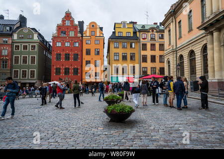 Stockholm, Schweden - 16. Juli 2019. Massen von Touristen in der Altstadt, Stockholm, ein Marktplatz mit bunten Gebäude erkunden. Stockfoto