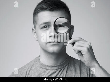 Portrait des jungen Mannes durch die Lupe suchen Stockfoto