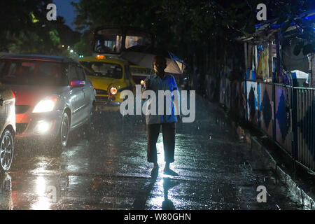 August 7, 2019, Kolkata, West Bengal, Indien: ein Mann auf der Straße mit einem Regenschirm in einer regnerischen Nacht in Kalkutta.. Gangetic West Bengalen, der zum größten Teil aus Kolkata ist die derzeit am meisten Regen mangelhaft Region des Landes mit einem Mangel an 47 % (Credit Bild: © Avijit Ghosh/SOPA Bilder über ZUMA Draht) Stockfoto