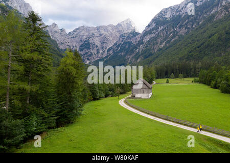 Mutter und Sohn Wandern auf Feldweg in der Nähe von Mountain Bauernhaus in den Europäischen Alpen, Robanov Kot, Solcava, Slowenien Stockfoto