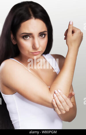 Schmerzen in den Ellenbogen. Das Mädchen hält ihre Hand für ein Kniestück. Schmerzhafte Empfindungen im Bereich der Hand. Dislokation. Bruch. Das Konzept der Gesundheit. Auf Stockfoto