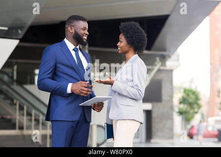 Attraktive afrikanischen Kollegen in angenehmen zusammen chatten Stockfoto