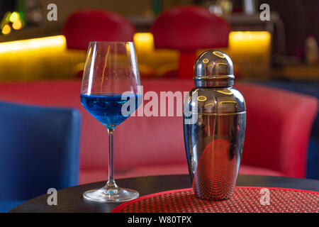 Cocktail blue lagoon aus Glas und Metall Shaker auf einen Tisch im Restaurant. Alkohol trinken und Night Club Konzept. Close Up, selektiver Fokus Stockfoto