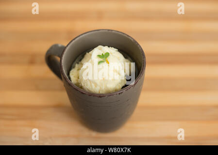Lemon Ice Cream Dessert mit Basilikumblätter in Becher über Holz- countertop serviert. Foto in der Stadt Rio de Janeiro, Brasilien. Jahr 2019. Stockfoto