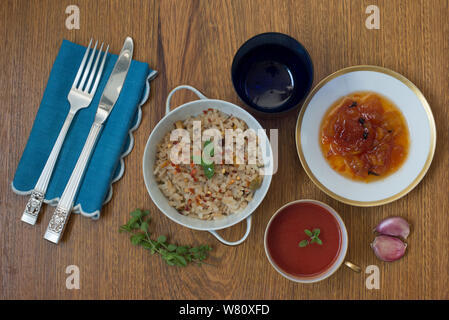 Italienische Tomatensuppe brauner Reis risotto Papaya dessert Porzellan Silber Besteck blau Leinen Serviette. Rio de Janeiro, Brasilien. Im Laufe des Jahres 2019. Stockfoto