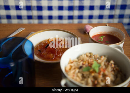 Italienische Tomatensuppe brauner Reis risotto Papaya dessert Porzellan Silber Besteck blau Leinen Serviette. Rio de Janeiro, Brasilien. Im Laufe des Jahres 2019. Stockfoto