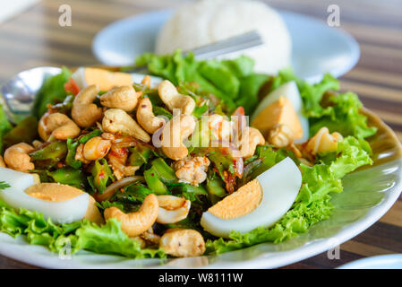 Thai wing Bean Shrimpsalat mit gekochtem Ei und Cashew-nuss und Reis an der Seite. Thai würzigen Salat. Stockfoto