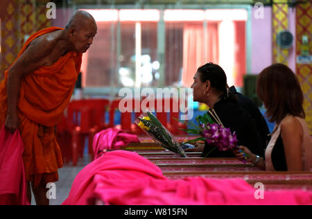 Thais Menschen gesehen in Särgen im Wat Takien Tempel in der Provinz Nonthaburi beten, am Stadtrand von Bangkok. Hunderte gläubige Buddhisten zahlen eine geringe Gebühr in rosa Särge liegen um 9:00 und 13:00 Uhr jeden Tag während der ungewöhnliche tägliche Auferstehung Service, dass Sie glauben, dass Sie Pech waschen und das Leben zu verlängern. Stockfoto