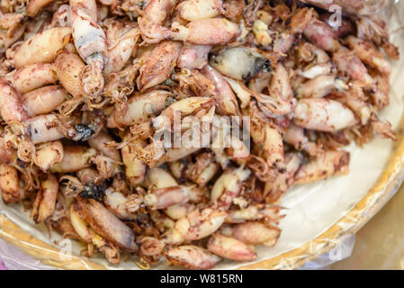 Ansicht von oben Heap von getrockneten kleinen Tintenfischen auf dem Korb sind im lokalen Meeresfrüchte Meeresfrüchte im Freien Markt in Thailand verkauft. Stockfoto