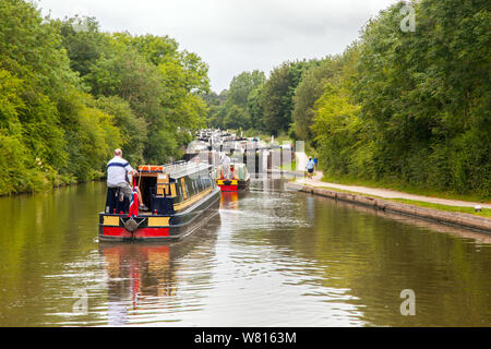 Kanalschrohboote, die sich nähern und durch Hatton Schleusen auf dem Grand Union Canal in Hatton Warwickshire, England, passieren. Ein Flug von 21 Schleusen Stockfoto