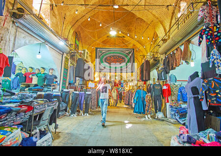 SHIRAZ, IRAN - Oktober 14, 2017: Die mittelalterliche Gasse der Vakil Basar mit Klamotten- und textile Ständen, am 14. Oktober in Shiraz. Stockfoto