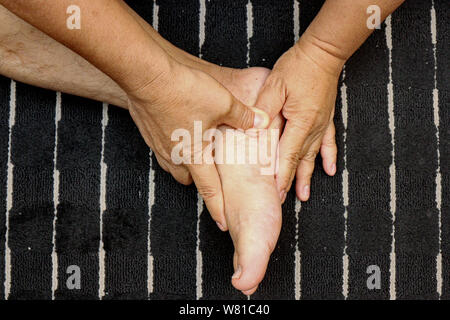 Behandlung von Verletzungen an den Füßen und Beinen mit einem Finger durch traditionelle Thai Massage. Stockfoto