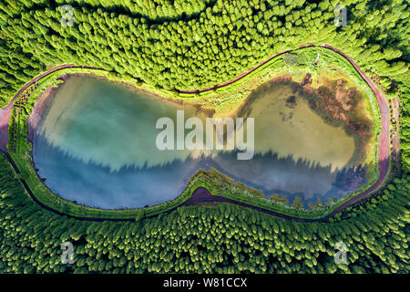 Gläser geformt drone Landschaft. Von oben nach unten Luftbild von einem kleinen Teich in der Mitte eines Waldes, die Wolken im Himmel. Vogelperspektive von Empadadas Stockfoto