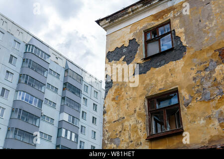 Verlassenen baufälligen Haus auf dem Hintergrund einer Wohngegend mehrstöckigen Panel Building Stockfoto