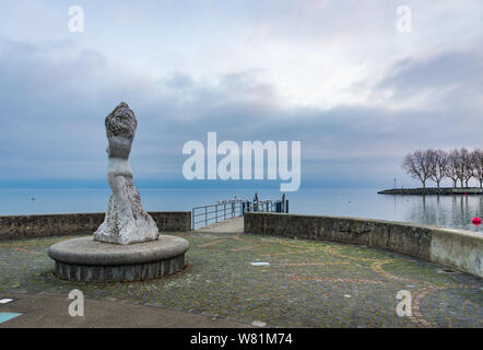 Skulptur Denkmal auf die Promenade am Ufer des Genfer Sees, ohne Menschen und den Hintergrund von Misty, bewölkt und Dämmerung Himmel über Wasser. Stockfoto