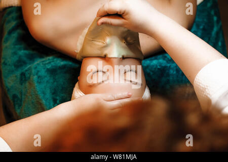 Zur Beseitigung der alginat Maske vom Gesicht einer Frau in einem Wellnesscenter. Stockfoto