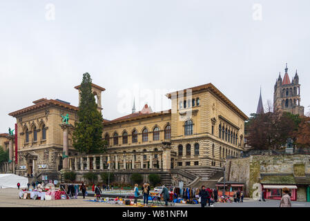 Im Hinblick auf Tätigkeiten und Flohmarkt um den Place de la Riponne und Hintergrund des Palais de Rumine Lausanne Kathedrale im Winter. Stockfoto