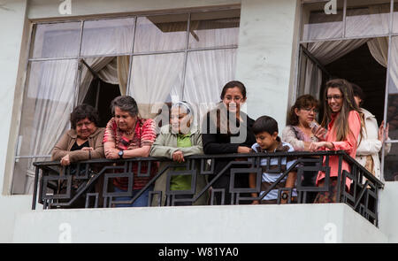 Cuenca, Ecuador - Dec 23, 2012: Familie schaut von Balkon auf Parade unter Stockfoto