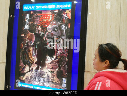 ---- Eine Chinesische filmgoer Spaziergänge hinter einem Plakat des Films "Die Reise nach Westen: Die Dämonen Schlagen zurück" in einem Kino in Kunshan City, Central Chinas Stockfoto