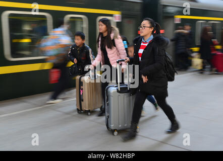 Chinesische Passagiere, die Rückkehr aus dem Chinesischen Neujahrsfest oder Spring Festival zu arbeiten, drücken Sie ihr Gepäck auf der Plattform an der Fuyang Railway Sta Stockfoto