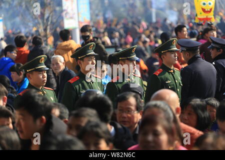 Die chinesischen paramilitärischen Polizisten stand Guard als Anbeter Masse die Taiping Brücke für gutes Glück am sechzehnten Tag des Chinesischen Neujahrsfest beten Stockfoto