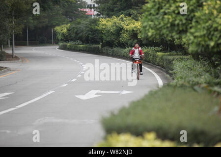 Ein Radfahrer fährt auf eine leere Straße während der chinesische Mondjahr, auch als Frühlingsfest, in Shenzhen City, South China Hainan Provinz bekannt, Stockfoto