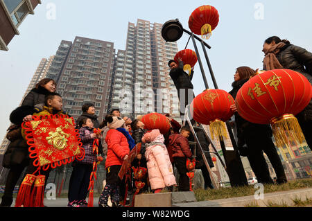 Lokale chinesische Bewohner beobachten ein freiwilliger Aufhängen rote Laternen auf einer Laterne die kommende Frühjahr Festival oder das Chinesische Neue Jahr (Ja zu feiern. Stockfoto