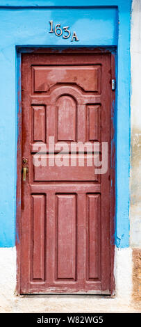 Trinidaad, Kuba 26.November 2017 - rote Tür auf blaue und weiße Wand Stockfoto