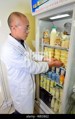 Chinesische cattleman Zeng Bo, ein Doktorat Inhaber, die in der Tierernährung von der Chinesischen Akademie der Wissenschaften, seine Milchprodukte in seiner direkten Kühlen - Verkauf Stockfoto