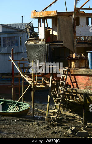 CASTRO, CHILE - Februar 6, 2016: Alte hölzerne Schiff mit Gerüst bei Ebbe im Flussbett des Gamboa Fluss in Castro, Chiloé Archipel, Chile Stockfoto