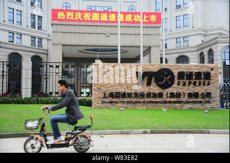 ---- Ein Radfahrer fährt mit dem Elektrofahrrad Vergangenheit der Sitz von YTO Express in Shanghai, China, 28. Oktober 2016. YTO Express Group ist auf der Suche nach r Stockfoto