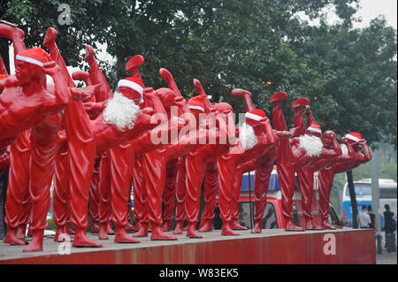 Red Bruce Lee Skulpturen verkleidet als Weihnachtsmann abgebildet, die außerhalb der Creative Industry Park in Foshan City, South China Guangdong Provinz, 21 Dez Stockfoto