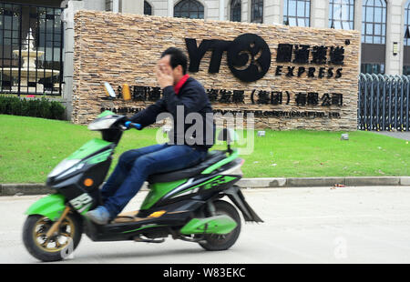 ---- Ein Radfahrer fährt mit dem Elektrofahrrad Vergangenheit der Sitz von YTO Express in Shanghai, China, 28. Oktober 2016. YTO Express Group ist auf der Suche nach r Stockfoto