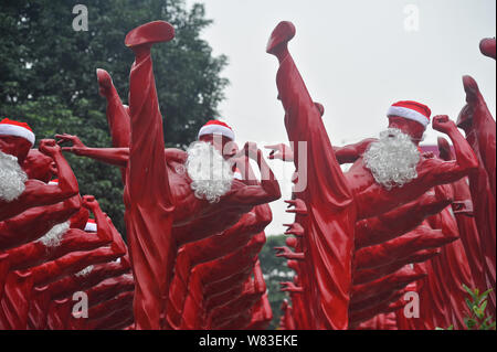 Red Bruce Lee Skulpturen verkleidet als Weihnachtsmann abgebildet, die außerhalb der Creative Industry Park in Foshan City, South China Guangdong Provinz, 21 Dez Stockfoto