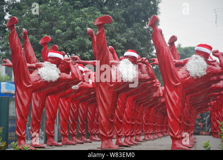 Red Bruce Lee Skulpturen verkleidet als Weihnachtsmann abgebildet, die außerhalb der Creative Industry Park in Foshan City, South China Guangdong Provinz, 21 Dez Stockfoto