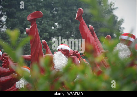 Red Bruce Lee Skulpturen verkleidet als Weihnachtsmann abgebildet, die außerhalb der Creative Industry Park in Foshan City, South China Guangdong Provinz, 21 Dez Stockfoto