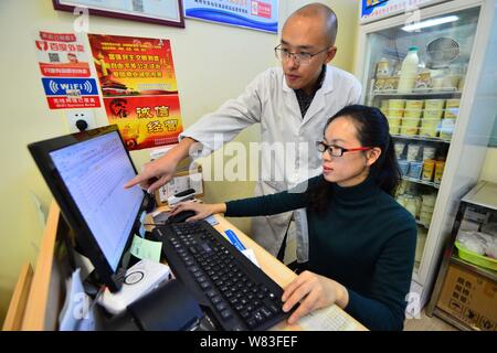 Chinesische cattleman Zeng Bo, ein Doktorat Inhaber, die in der Tierernährung von der Chinesischen Akademie der Wissenschaften, und seine Frau Huang Nana befassen sich mit Bestellung des Kunden Stockfoto