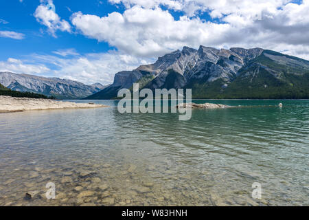 Lake Minnewanka - ein Frühling Blick auf Crystal Clear Lake Minnewanka, mit robustem Fairholme Bereich hoch am Südufer, Banff National Park, Kanada. Stockfoto