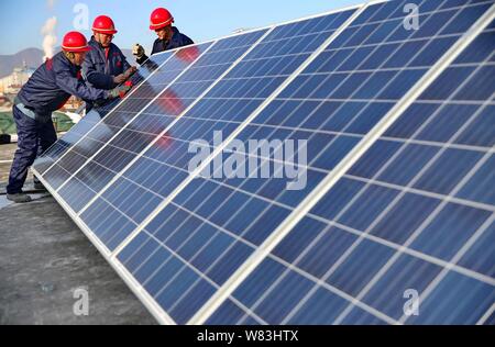 ------ Chinesische Arbeiter installieren Solaranlagen auf dem Dach eines Hauses in Duzhuang Duzhuang Dorf, Stadt, Qinhuangdao Stadt, in Nordchina Hebei provi Stockfoto