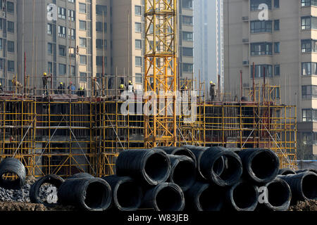 ------ Chinesische Wanderarbeiter ein hohes Gebäude auf der Baustelle eine Wohn- Projekt in Huaian Stadt konstruieren, Ea Stockfoto