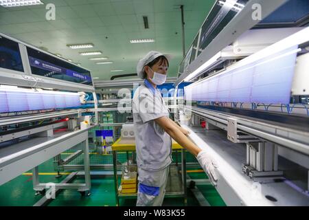 ---- Eine weibliche chinesischer Arbeiter überwacht die Herstellung von Solarzellen verwendet werden Solarzellen im Werk von Lanzhou Shenzhou neue Ene zu machen Stockfoto