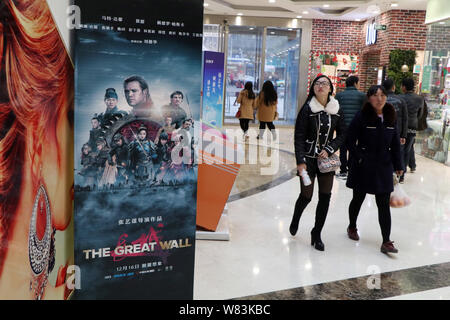 Menschen gehen vorbei an einem Plakat des Films "Die Mauer" am Wanda Plaza in Kunshan City, Central China Provinz Hubei, 10. Dezember 2016. "Die tolle Stockfoto