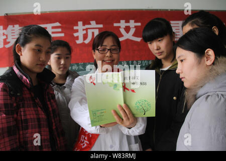 Ein chinesischer medizinischer Arbeiter propagandizes Vorbeugung von HIV und AIDS zu den weiblichen Studierenden an einer beruflichen Schule in Boxen County, Binzhou c Stockfoto
