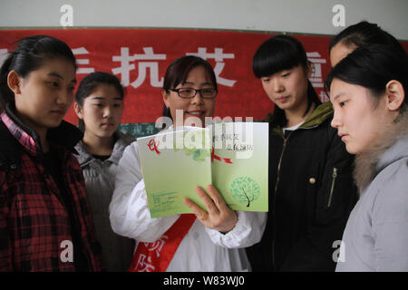 Ein chinesischer medizinischer Arbeiter propagandizes Vorbeugung von HIV und AIDS zu den weiblichen Studierenden an einer beruflichen Schule in Boxen County, Binzhou c Stockfoto