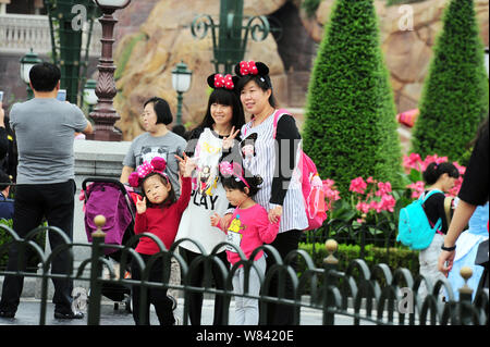 ---- Touristen tragen Mickey Mouse headwear posieren für Fotos im Shanghai Disneyland an der Shanghai Disney Resort in Pudong, Shanghai, China, 14. Stockfoto