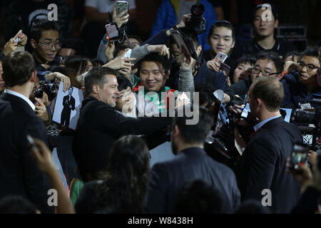 Amerikanische Schauspieler Brad Pitt, zweite links, nimmt selfie mit einem chinesischen Fan, wie er auf dem roten Teppich für eine Pressekonferenz kommt an seinem neuen Film zu fördern. Stockfoto