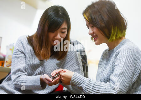 Chinesische e-commerce Schmuck Käufer Miffy, rechts, hilft Ihren Kunden heraus zu versuchen, Schmuck von ihr in Shanghai, China, 9. November 2016 vorgesehen. Miffy, einem j Stockfoto